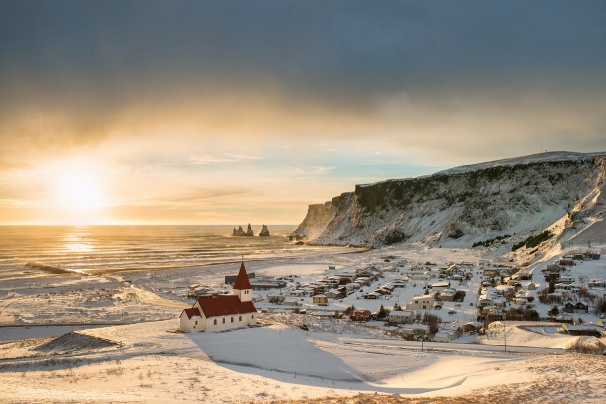 Vík í Mýrdal o wschodzie słońca, kościół na wzgórzu i klify nad oceanem